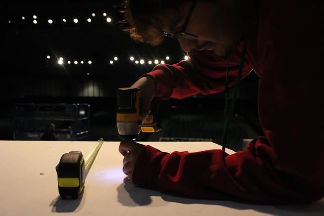 Student driving screws on a set platform